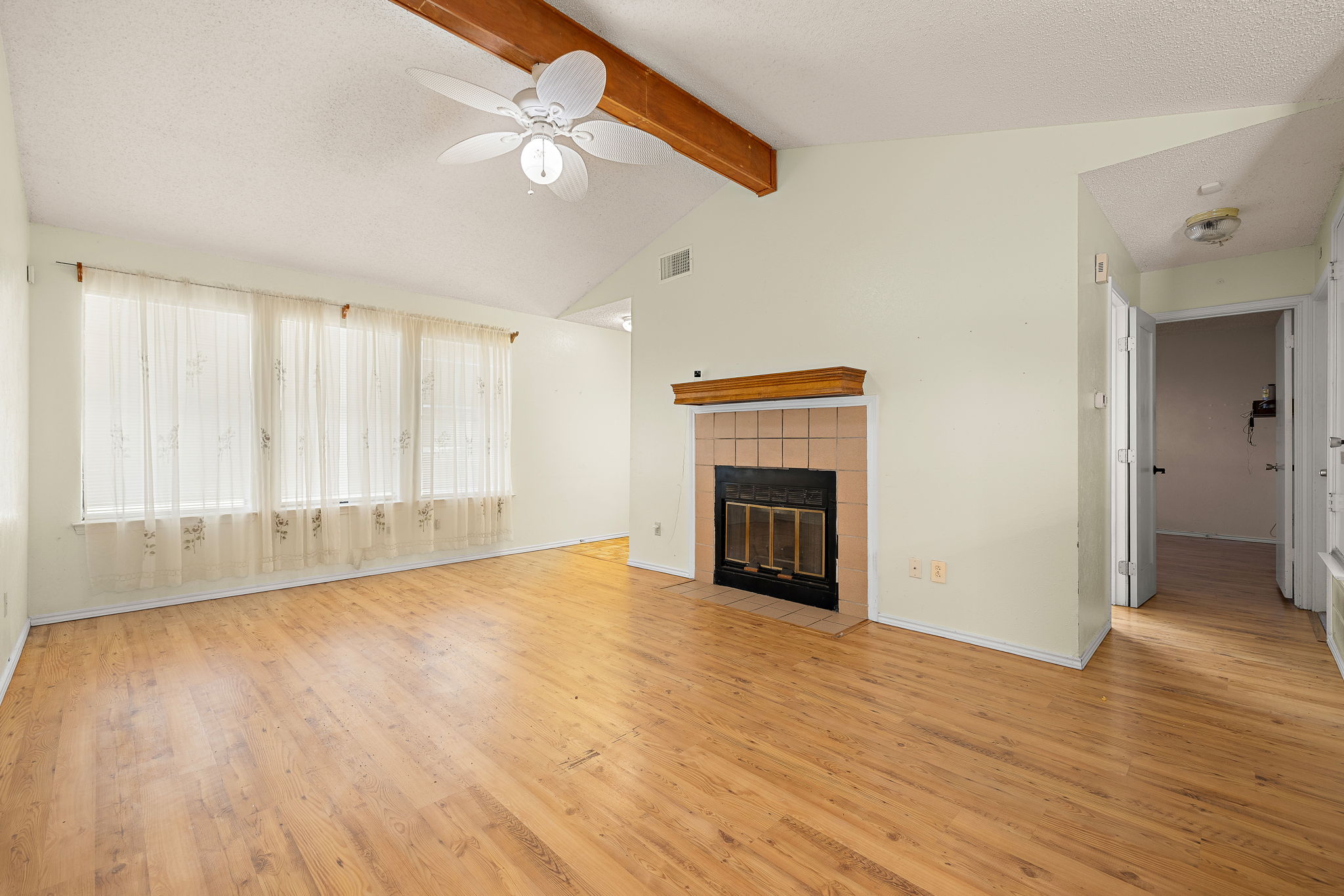 11709 Rotherham Drive Austin, TX 78753 - Photo 3 of 25 Vaulted ceilings and warm wood floors define this inviting living room, centered by a charming fireplace.