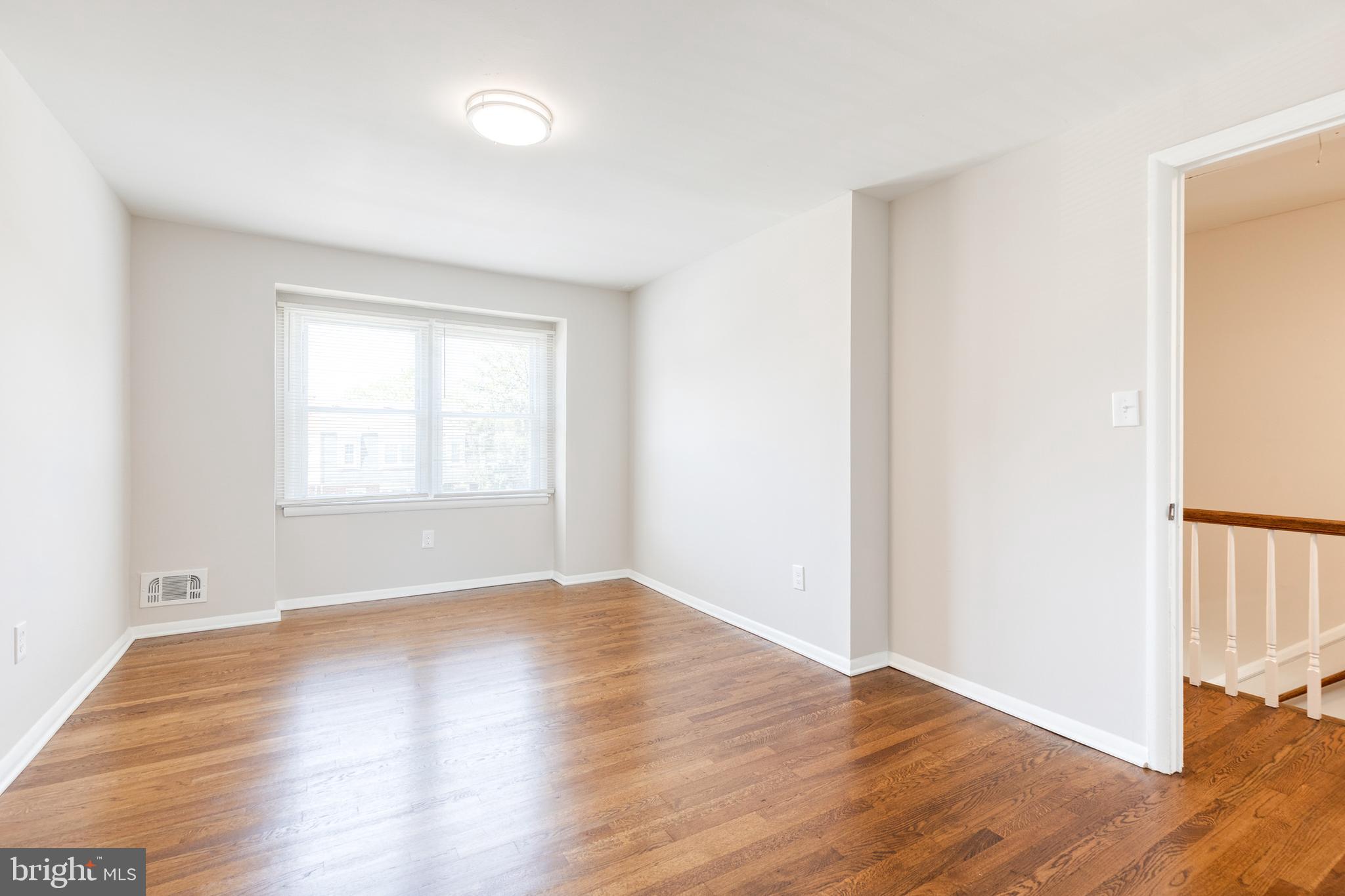 5649 Utrecht Road Baltimore, MD 21206 - Photo 24 of 42 a view of an empty room with wooden floor and a window