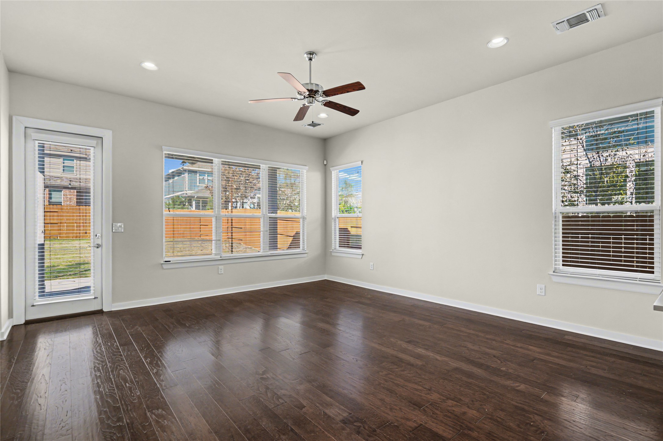 7216 Cherry Beam Path Austin, TX 78744 - Photo 11 of 32 a view of an empty room with wooden floor and a window