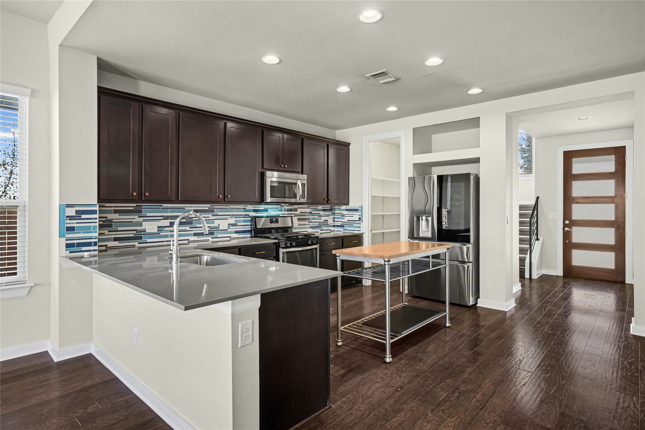 7216 Cherry Beam Path Austin, TX 78744 - Photo 7 of 32 a kitchen with stainless steel appliances kitchen island granite countertop a stove refrigerator and cabinets