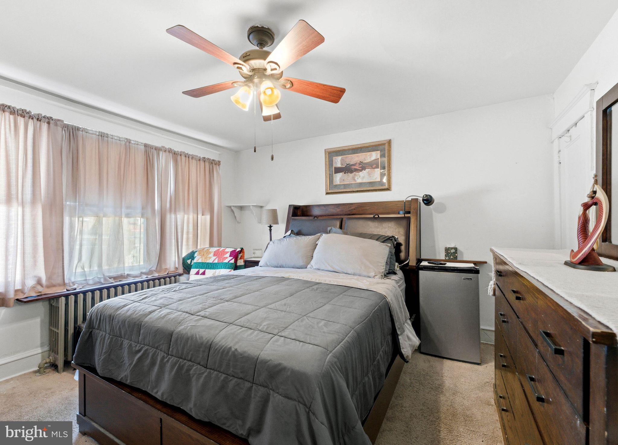 7828 Michener Avenue Philadelphia, PA 19150 - Photo 13 of 23 a bedroom with a bed and a chandelier