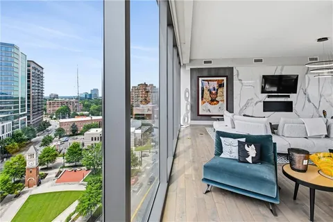 a large white kitchen with lots of counter top space a refrigerator and a view of living room