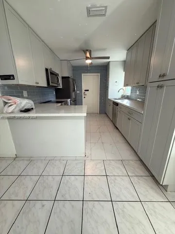 a kitchen with stainless steel appliances a sink and a refrigerator