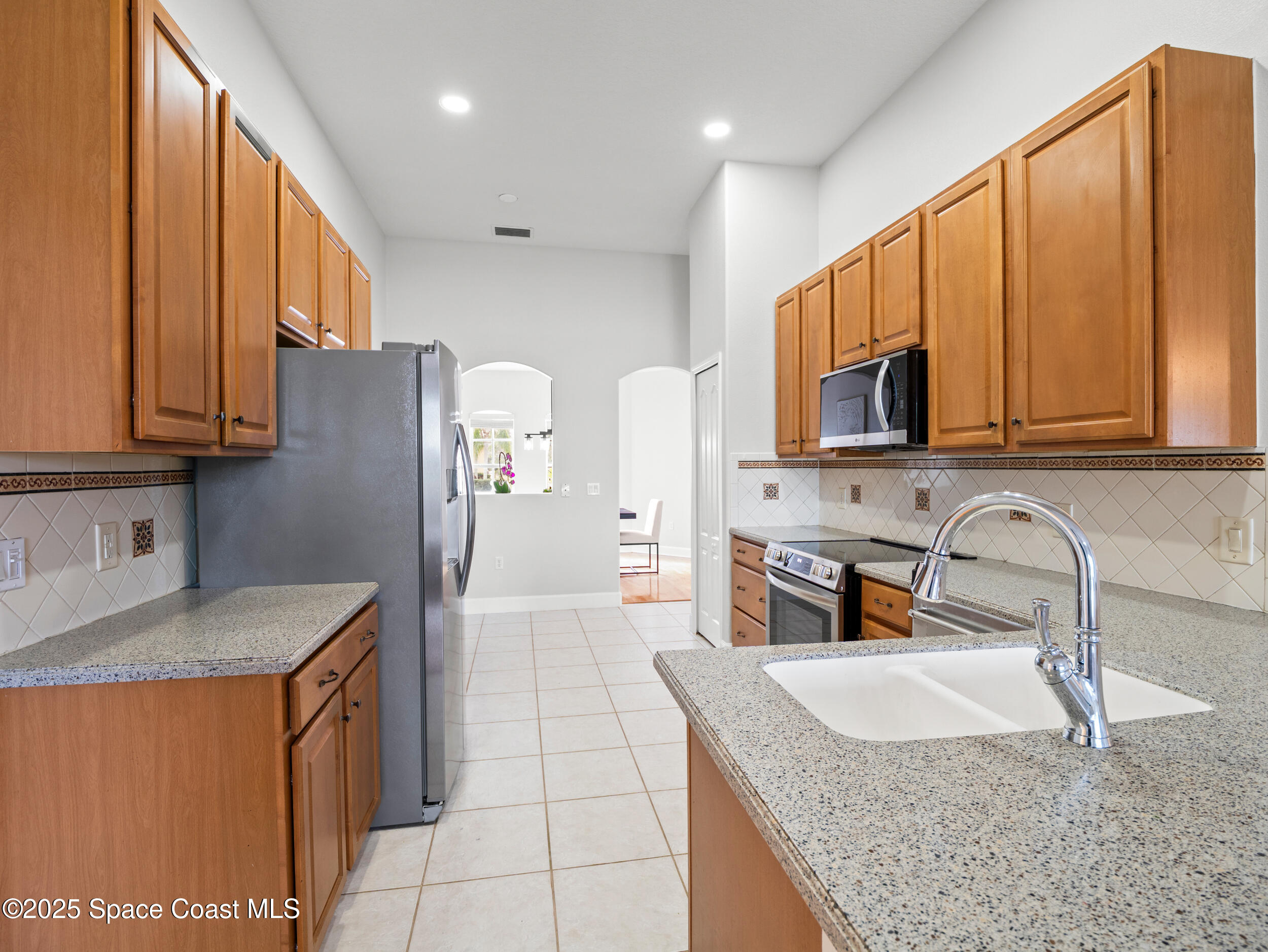 5015 Pinot Street Rockledge, FL 32955 - Photo 11 of 46 a kitchen with stainless steel appliances granite countertop a sink stove and refrigerator