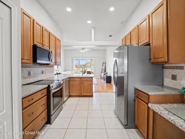 a kitchen with stainless steel appliances granite countertop a refrigerator and a stove