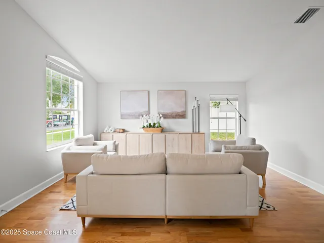 a living room with furniture and a wooden floor