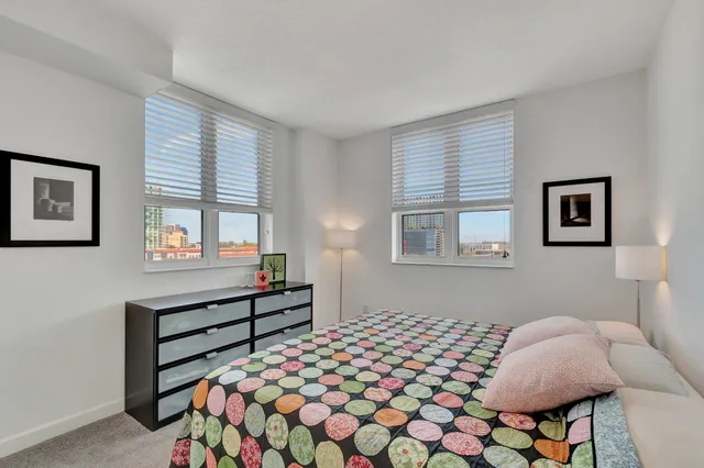 a bedroom with a bed and dresser with window