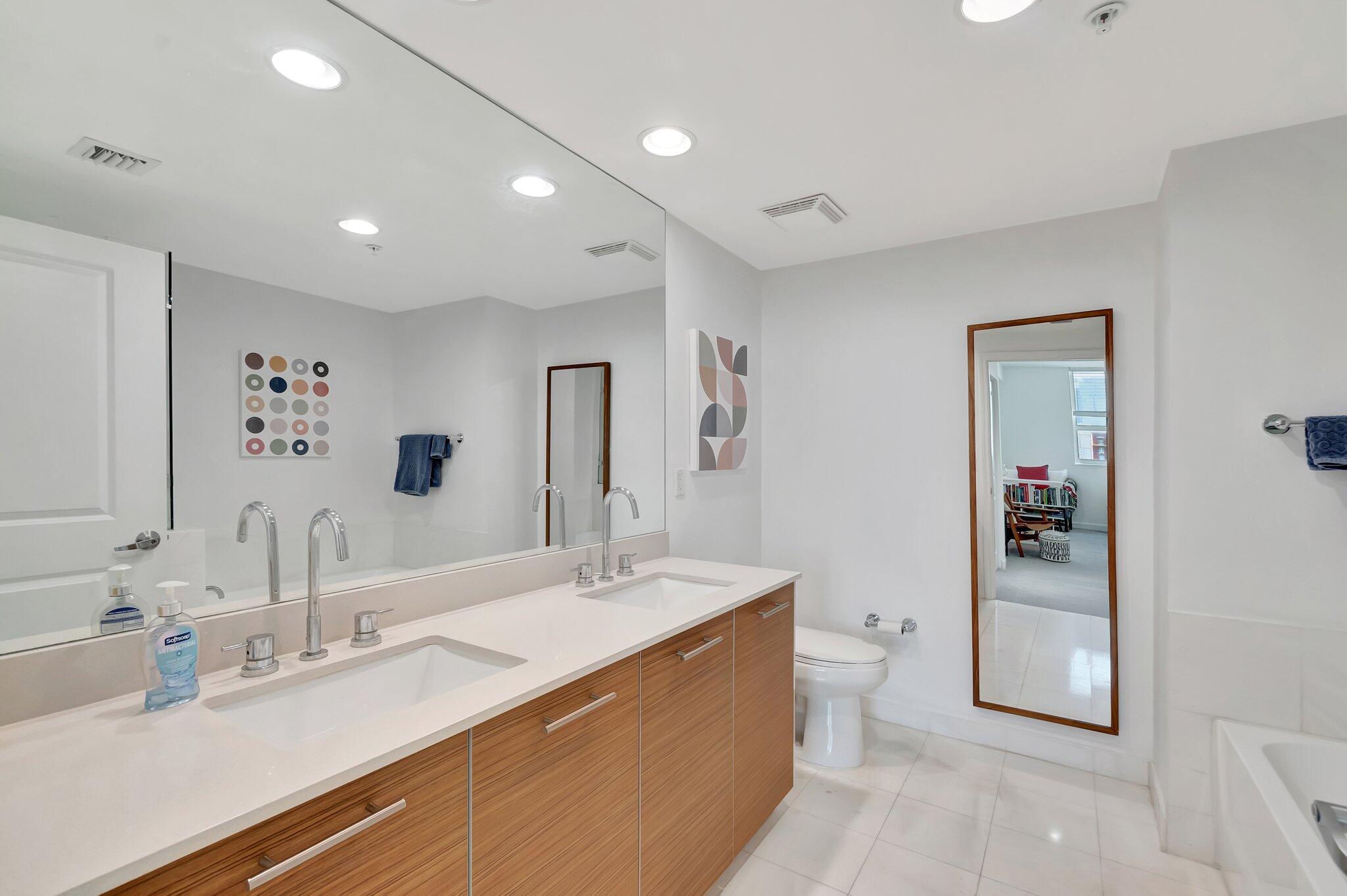 480 Hibiscus Street, Unit 709 West Palm Beach, FL 33401 - Photo 25 of 39 a bathroom with a double vanity sink a mirror and toilet