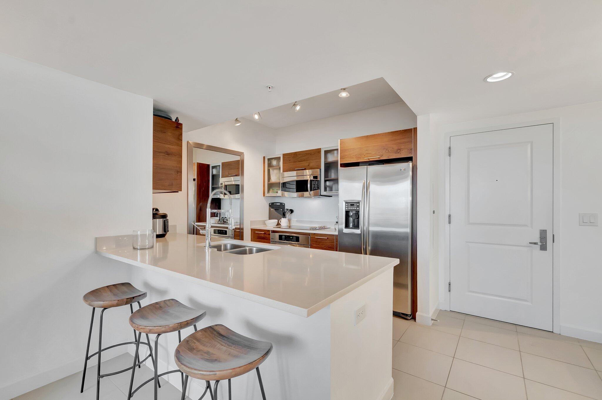 480 Hibiscus Street, Unit 709 West Palm Beach, FL 33401 - Photo 6 of 39 a kitchen with stainless steel appliances a sink and a refrigerator