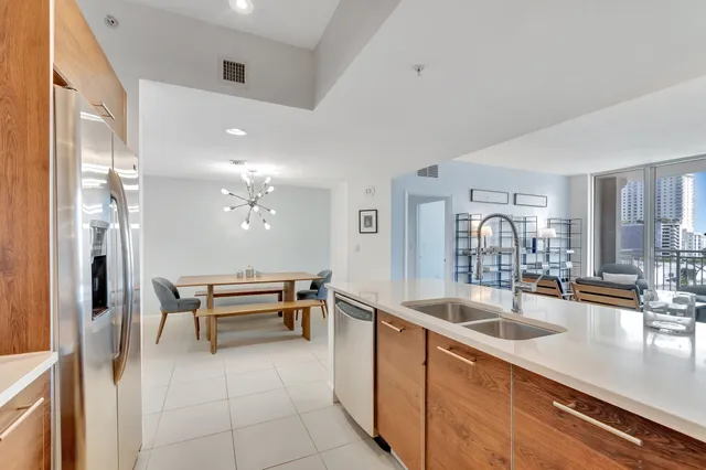 a dining hall with granite countertop a refrigerator a sink and living room view