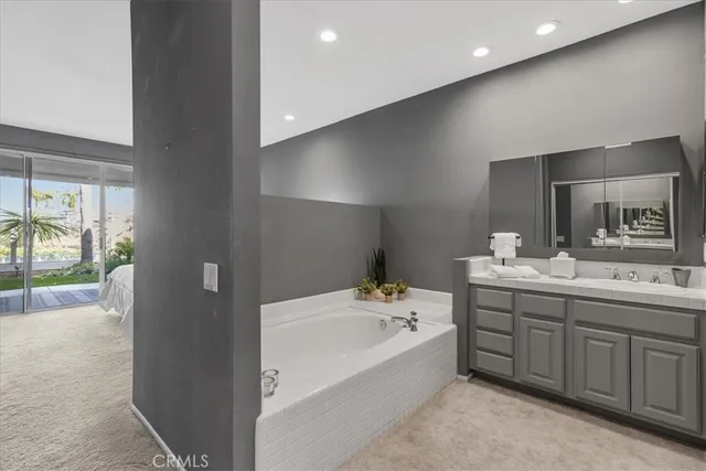 a bathroom with a tub sink and mirror