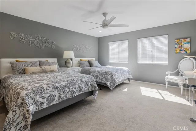 a bedroom with two beds and windows
