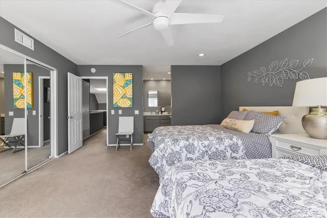 a bedroom with a bed and large mirror with furniture