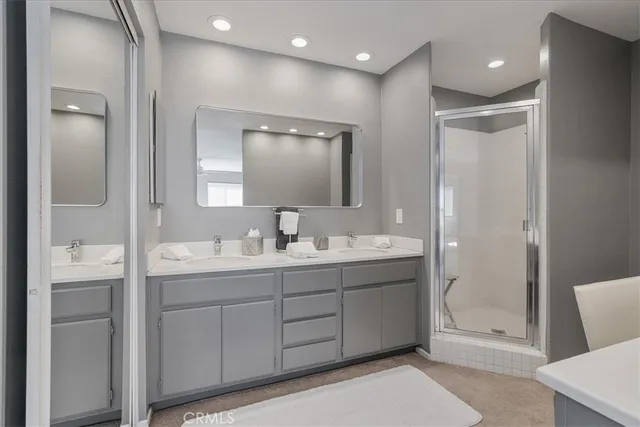 a bathroom with a double vanity sink mirror and shower