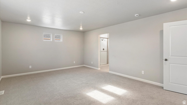 82 Provo River Road, Unit 251 Saratoga Springs, UT 84045 - Photo 18 of 32 Spacious carpeted room featuring recessed lighting, two high windows, white trim, and a white paneled door