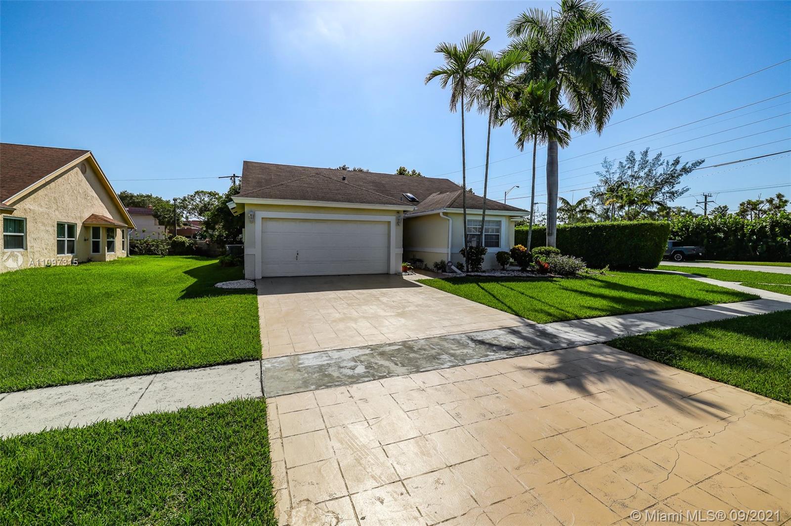 5140 Northwest 5th Avenue Boca Raton, FL 33487 - Photo 2 of 44 a front view of a house with a garden and palm trees