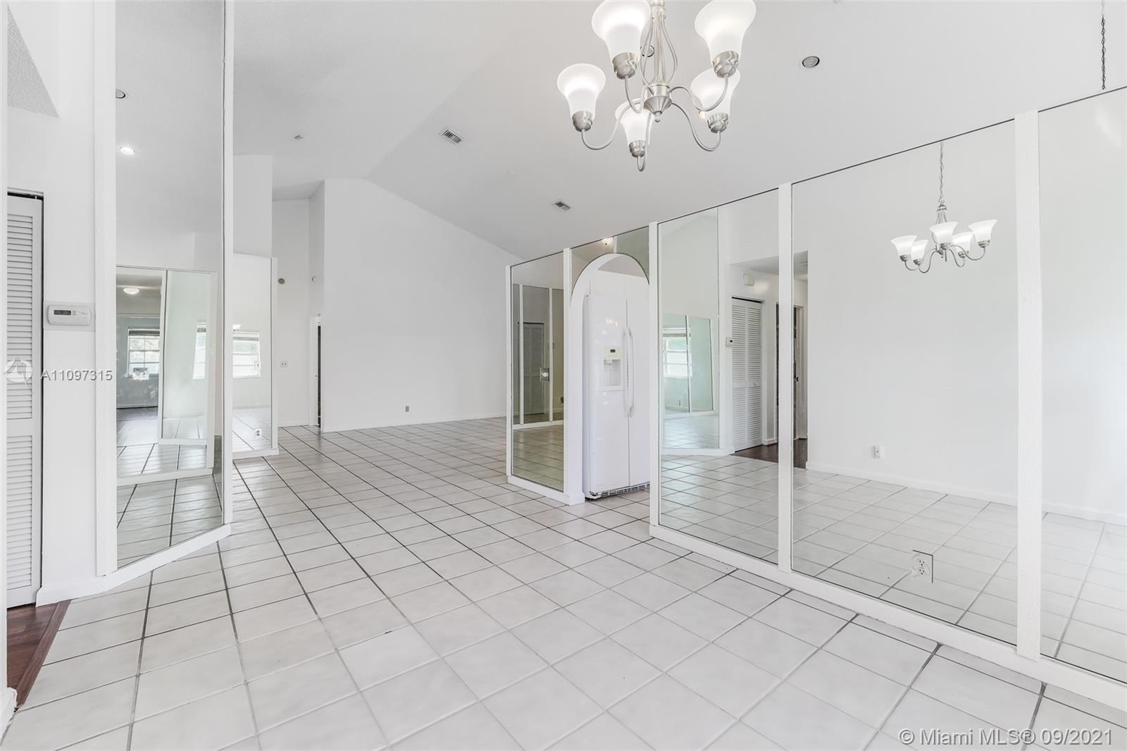 5140 Northwest 5th Avenue Boca Raton, FL 33487 - Photo 18 of 44 a view of a hallway with wooden floor and a chandelier