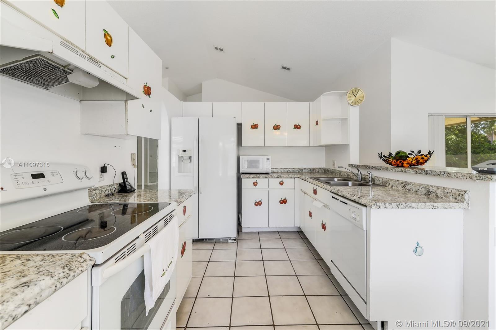 5140 Northwest 5th Avenue Boca Raton, FL 33487 - Photo 39 of 44 a kitchen with granite countertop a sink stove and cabinets