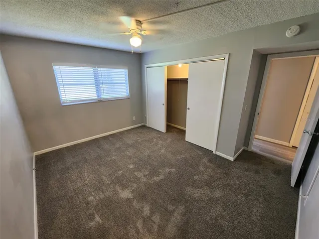 an empty room with windows and fan