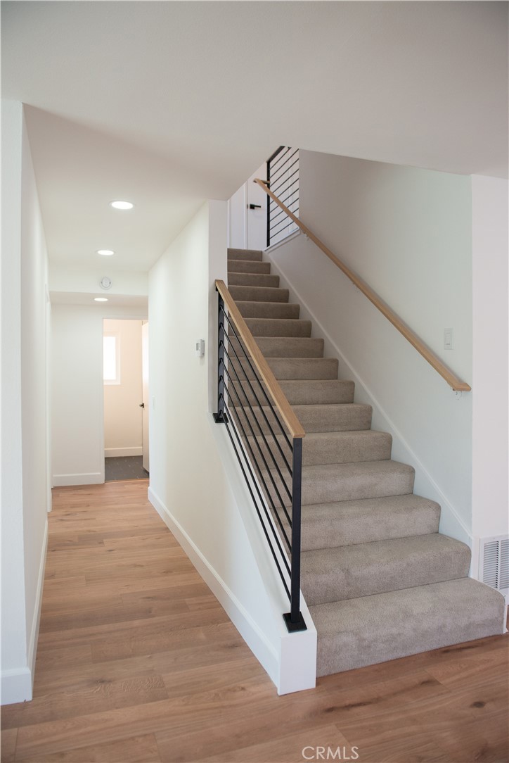 1466 East Helmick Street Carson, CA 90746 - Photo 16 of 32 a view of a hallway with stairs and wooden floor