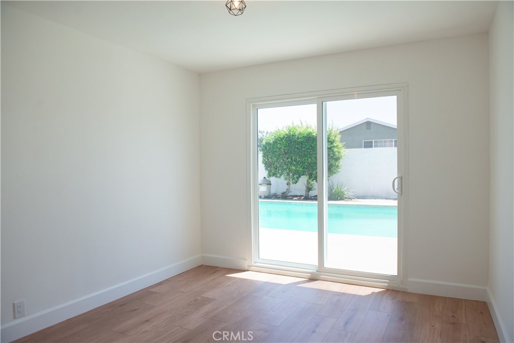 1466 East Helmick Street Carson, CA 90746 - Photo 17 of 32 an empty room with wooden floor and balcony