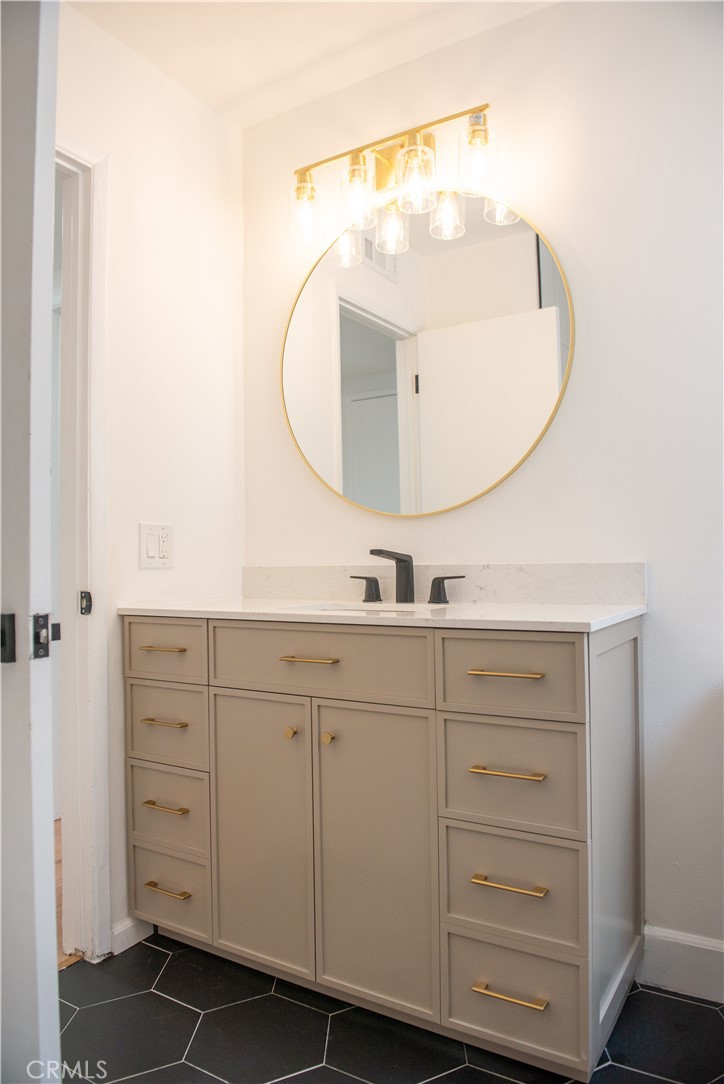 1466 East Helmick Street Carson, CA 90746 - Photo 19 of 32 a bathroom with a sink mirror and vanity