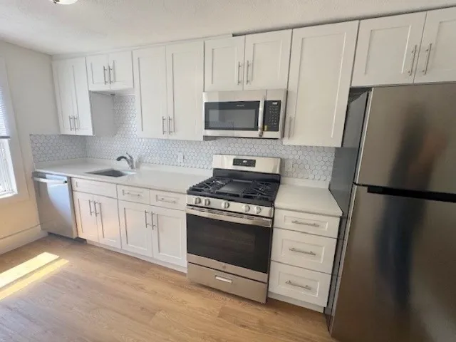 a kitchen with stainless steel appliances a refrigerator stove and sink