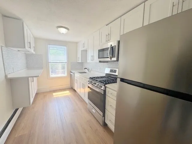 a kitchen with stainless steel appliances a refrigerator sink and microwave
