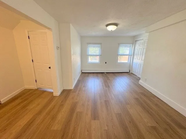 a view of a room with wooden floor and window