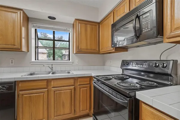 a kitchen with granite countertop a sink stove and cabinets