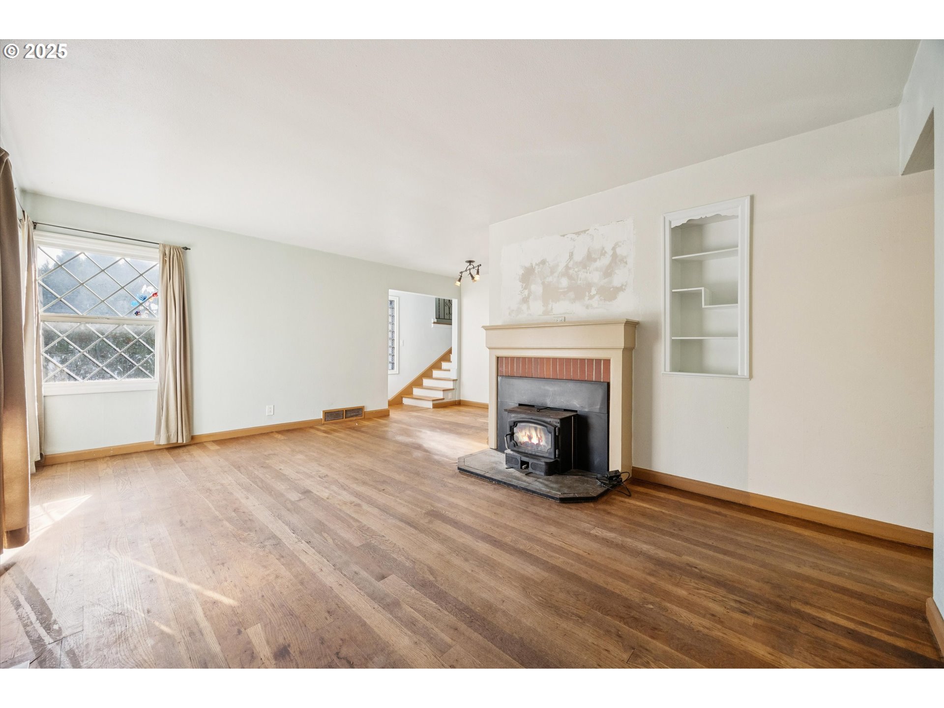 1115 Northeast 106th Avenue Portland, OR 97220 - Photo 11 of 46 a view of an empty room with wooden floor fireplace and a window