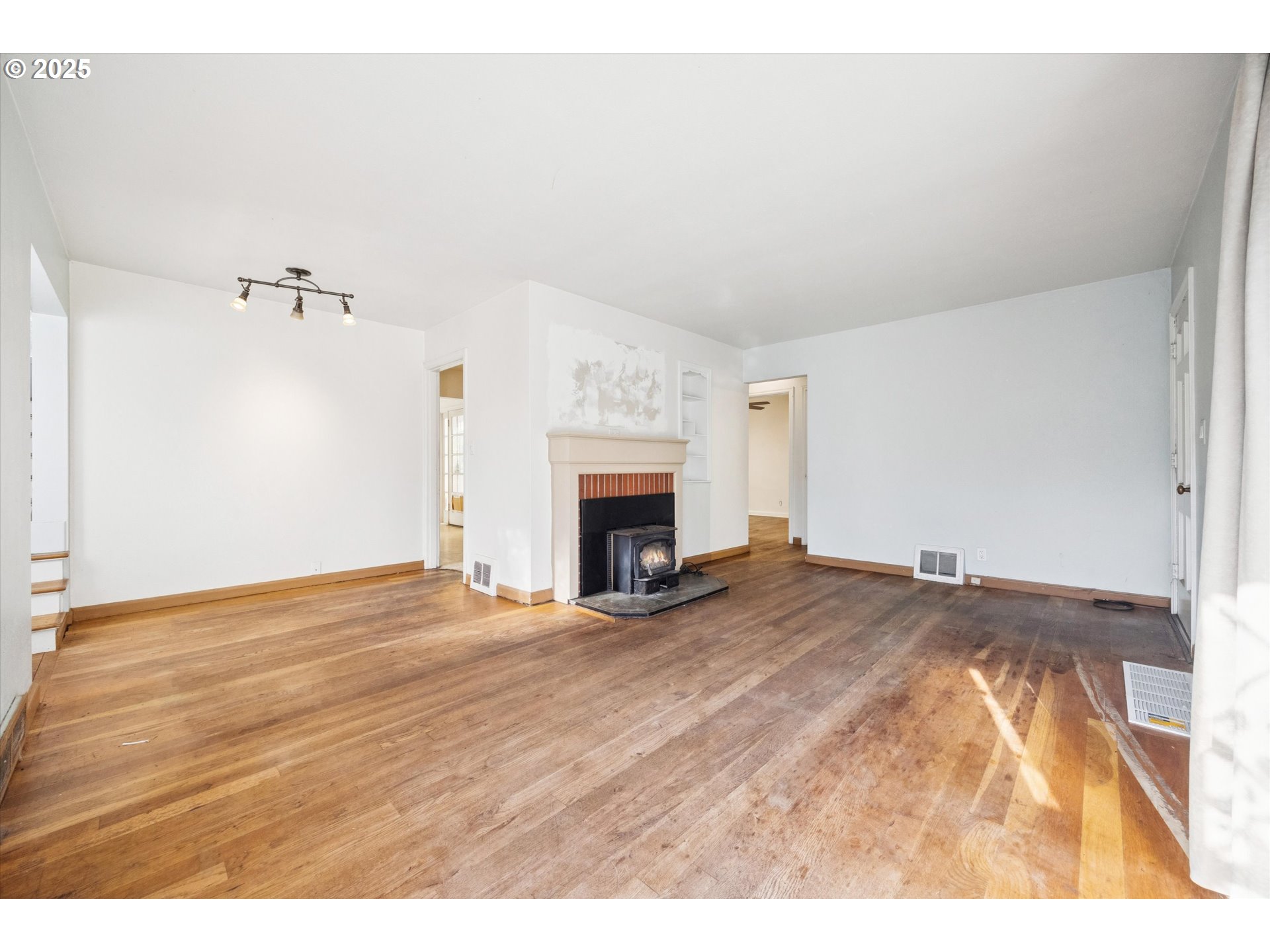 1115 Northeast 106th Avenue Portland, OR 97220 - Photo 9 of 46 a view of empty room with wooden floor and fireplace