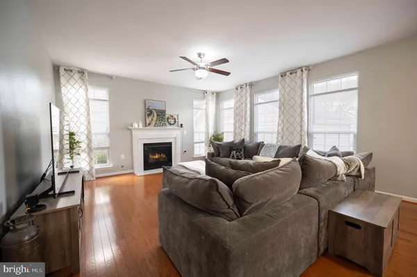 a kitchen with stainless steel appliances kitchen island granite countertop a refrigerator a sink dishwasher a stove and white cabinets with wooden floor