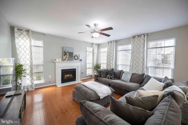 a large kitchen with stainless steel appliances granite countertop a stove top oven a sink dishwasher a refrigerator and white cabinets with wooden floor