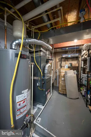 a utility room with stainless steel appliances furniture and a fireplace