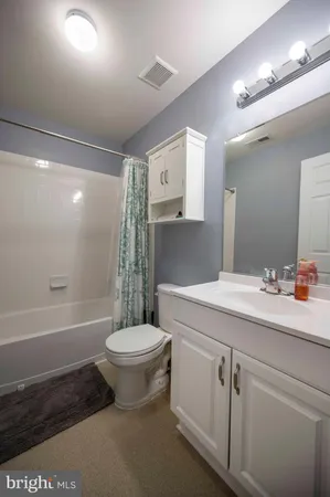 a spacious bathroom with double vanity a mirror and a shower