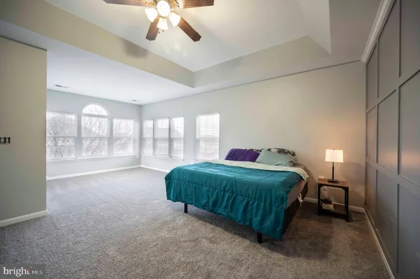 a bedroom with a bed table chair and a window