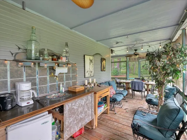 a room with stainless steel appliances kitchen island granite countertop a table chairs in it and wooden floor