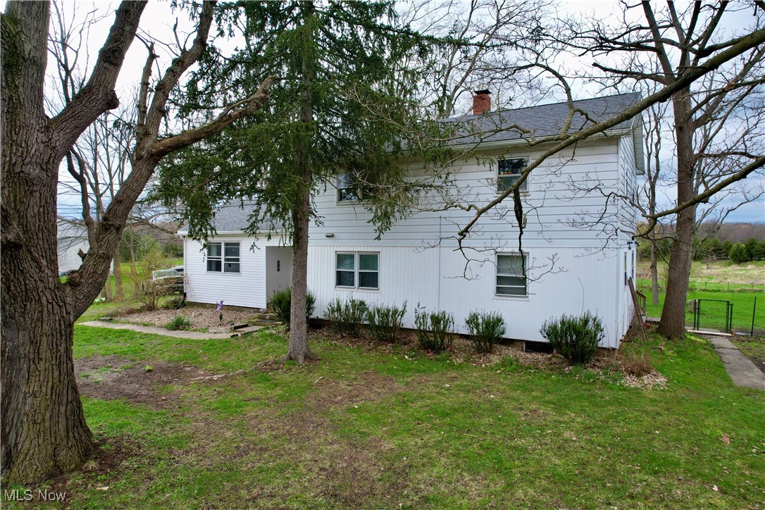 8195 Nichols Road Windham, OH 44288 - Photo 30 of 41 Back of house with a yard, a shingled roof, a chimney, and fence