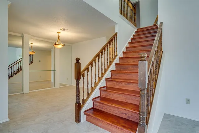 a view of a hallway with wooden floor and stairs