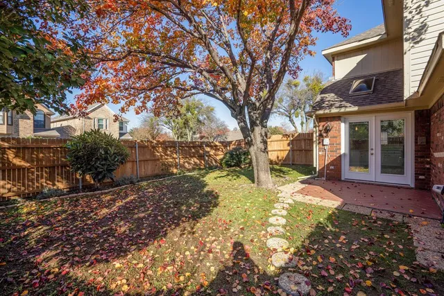 a backyard of a house with a large tree