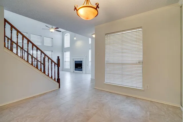 an empty room with windows and fireplace