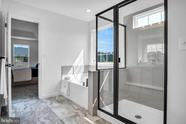 a view of a hallway with bathroom and glass door