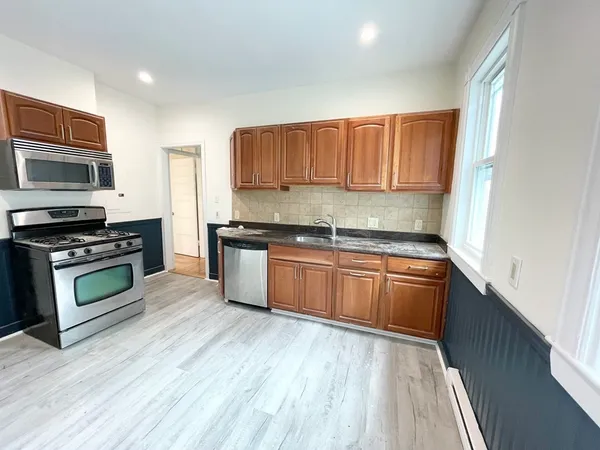 a kitchen with stainless steel appliances kitchen island granite countertop a stove a sink and a microwave