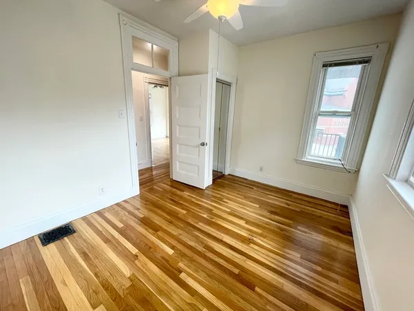 a view of empty room with window and ceiling fan
