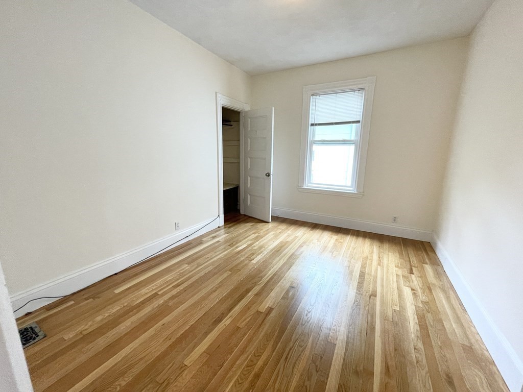 72 Roseclair Street, Unit 2 Boston, MA 02125 - Photo 12 of 14 an empty room with wooden floor and windows