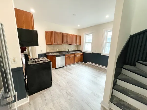 a kitchen with stainless steel appliances granite countertop a refrigerator a stove top oven a sink and dishwasher