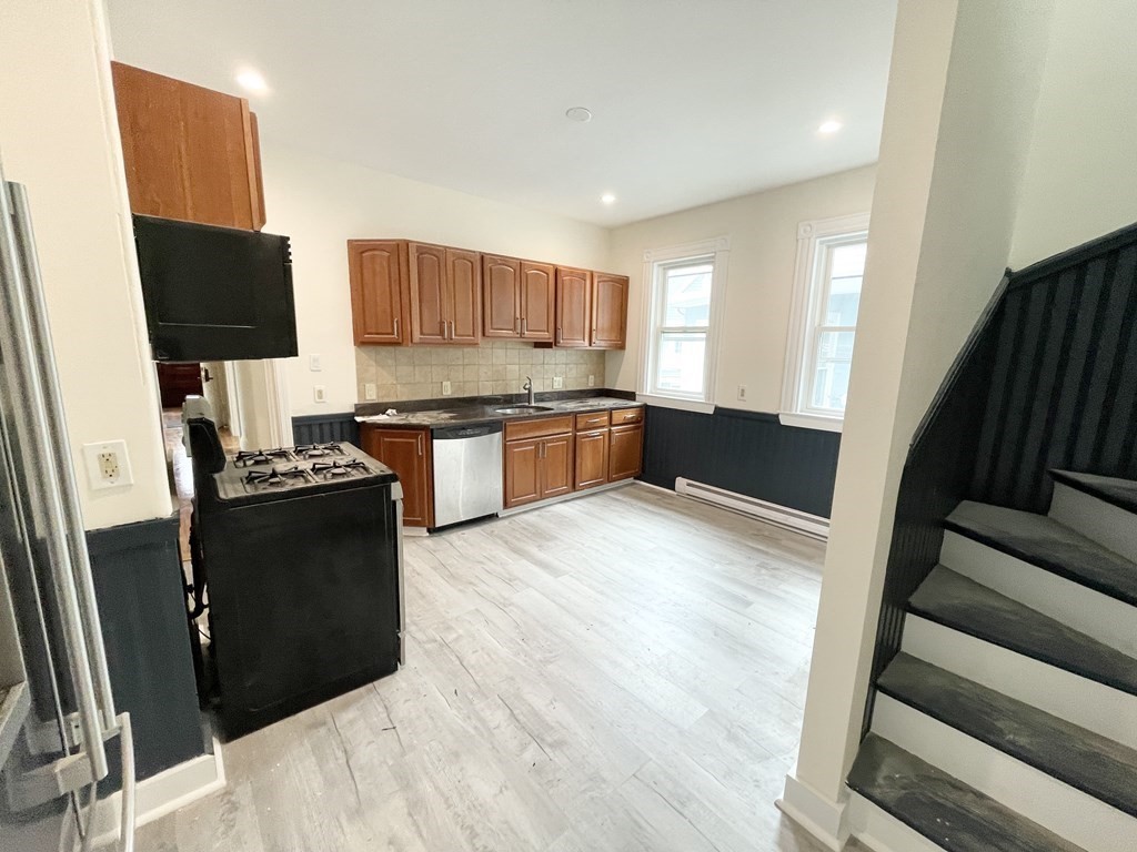 72 Roseclair Street, Unit 2 Boston, MA 02125 - Photo 4 of 14 a kitchen with stainless steel appliances granite countertop a refrigerator a stove top oven a sink and dishwasher