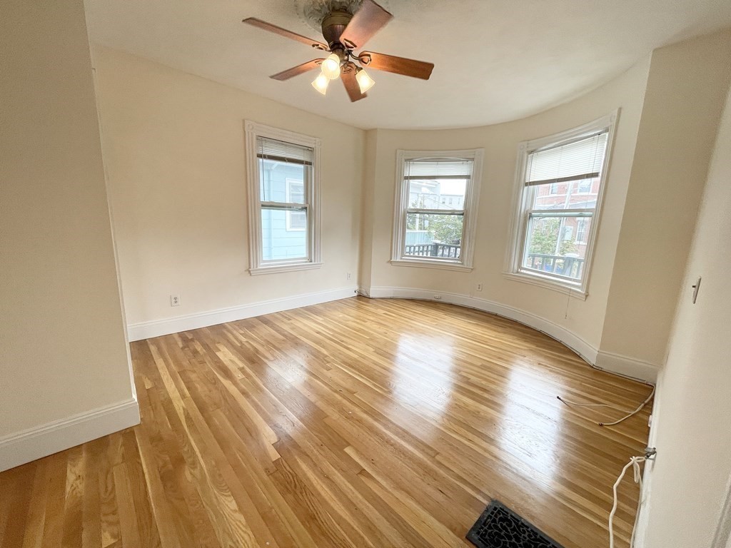 72 Roseclair Street, Unit 2 Boston, MA 02125 - Photo 5 of 14 a view of empty room with wooden floor and fan