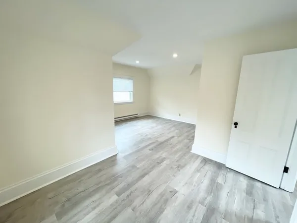 a view of an empty room with wooden floor